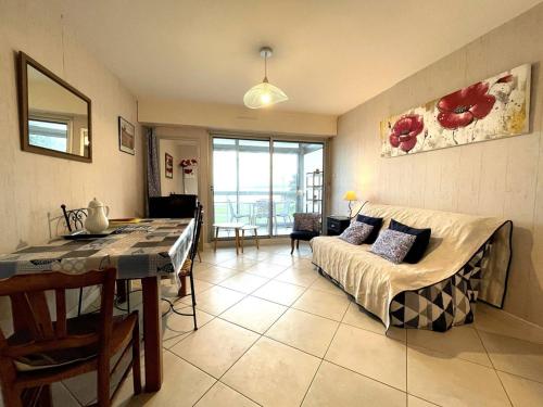 un salon avec un canapé et une table dans l'établissement Appartement 3* à Perros-Guirec, plage à 50m, garage privé - FR-1-368-73, à Perros-Guirec