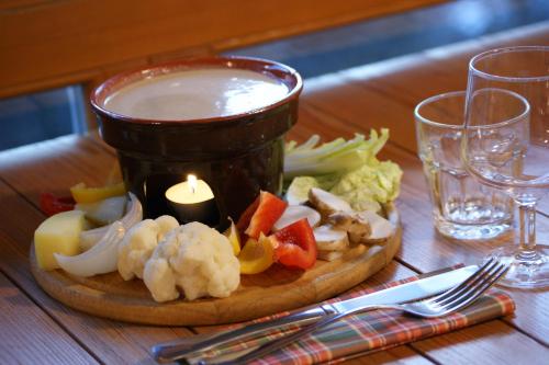 a plate of food with a candle and vegetables on a table at Rifugio Galaberna in Ostana