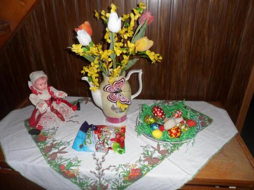 a table with a vase with flowers and a doll on it at Pension Mikulka in Mikulov v Krušných Horách