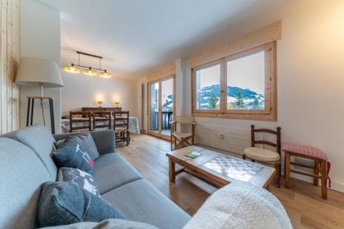 un salon avec un canapé bleu et une table dans l'établissement Appartement à Megève skis aux pieds - La CABOCHE, à Le Planellet