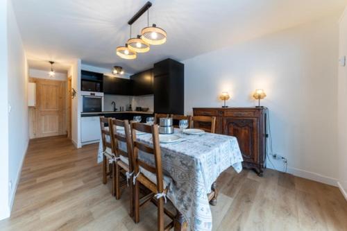 une cuisine avec une table et des chaises dans une pièce dans l'établissement Appartement à Megève skis aux pieds - La CABOCHE, à Le Planellet