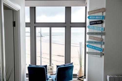 a room with two chairs and a view of the beach at The Pearl Suite by Margate Suites in Margate