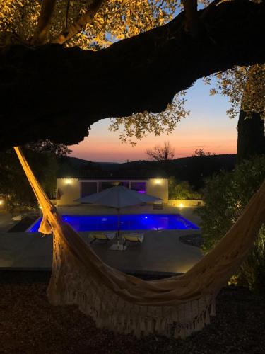 - un hamac en face de la piscine la nuit dans l'établissement Propriété : 300 M² + (25 M² d'annexe / Pool House) sur 5 ha boisé à 10' d'Aix en Provence, à Beaurecueil