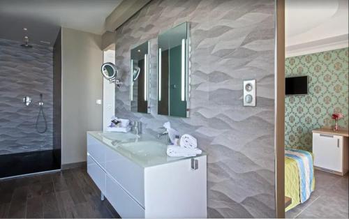 un bagno con lavandino e specchio di Villa moderne avec piscine privée à Olmeto - 95 m² a Olmeto
