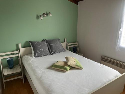 une chambre avec un lit blanc avec deux oreillers dans l'établissement Maison 6 pers à 400 m de la plage avec wifi et piscine chauffée, à Bretignolles-sur-Mer