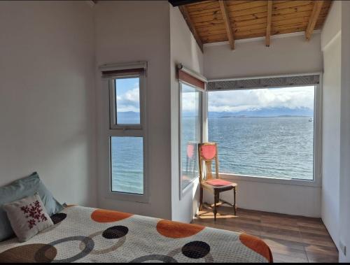 a bedroom with a bed and a window overlooking the water at Departamento Ushuaia in Ushuaia