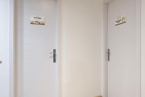 two white doors in a bathroom with a mirror at Next'Living - Luxury Private Room in a CoLiving Villa in Dubai