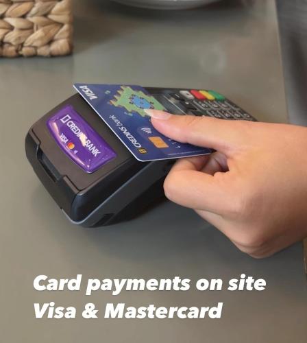 a person holding a credit card and a remote control at E&R Apartments at Myslym Shyri in Tirana