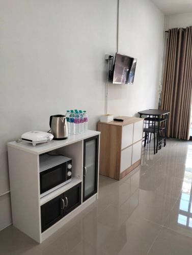a kitchen with a counter and a tv in a room at KNT Dwelling We are Hometel in Ban Na Khwai