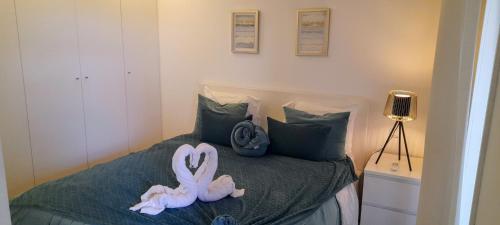 a bed with two stuffed animals on it at Light Brown Central Apartment in Aveiro