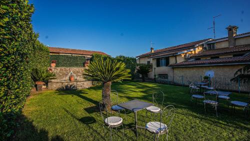 a yard with chairs and a table and a palm tree at Casale Colle dell'Asino in Ciampino