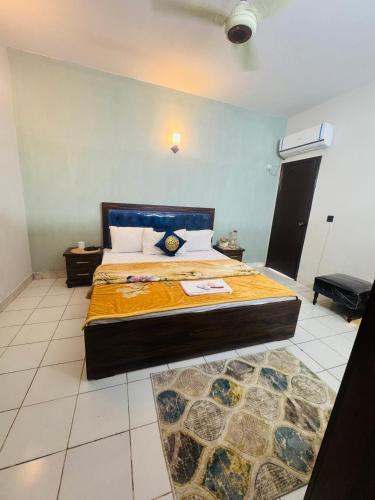 une chambre avec un grand lit dans une pièce dans l'établissement Rosewood Cottage, à Karachi