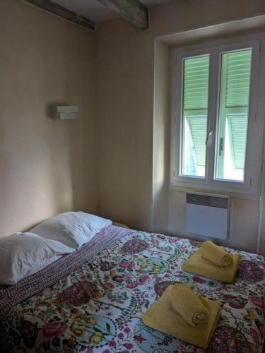une chambre avec un lit avec deux serviettes dessus dans l'établissement Séjour authentique avec vue mer à Menton, à Menton