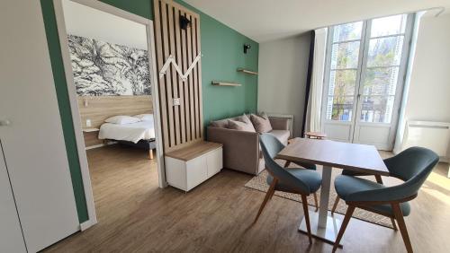 a room with a table and chairs and a bedroom at Première Pierre in Verdelais
