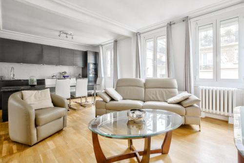 un salon avec un canapé et une table dans l'établissement Appartement au coeur du 17eme, à Paris