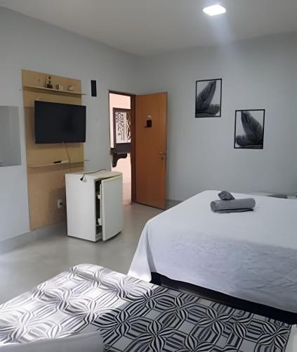 a bedroom with a bed and a flat screen tv at Rio Quente - Pousada do Charme in Rio Quente