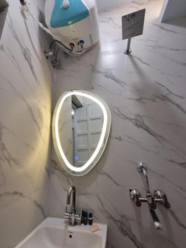 a bathroom with a sink and a mirror on a wall at Lucky Restaurant & Guest House in Agra