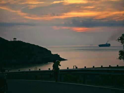 a person standing on a wall near the ocean at Without Asking East or West in Zhoushan