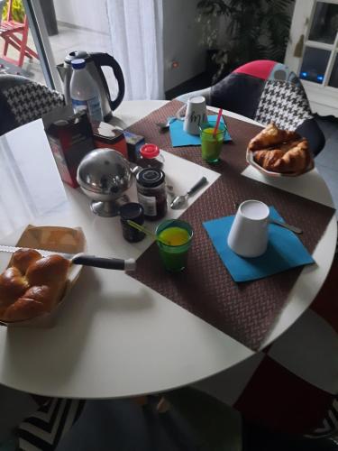 a table with bread and a plate of food on it at la conviviale in Bénouville