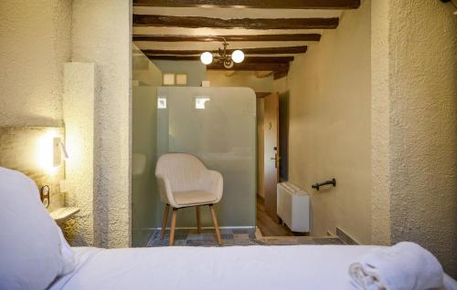 a bedroom with a white chair in a room at Lovely Home In Vilosell With Wifi in El Vilosell