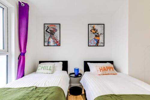 two twin beds in a room with purple curtains at Prime location, Panoramic city views, Surround Balcony Near Train Stn - Central Luton in Luton
