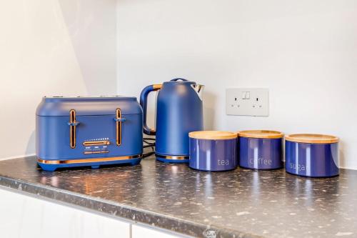 a counter with four blue suitcases and drums on it at Prime location, Panoramic city views, Surround Balcony Near Train Stn - Central Luton in Luton