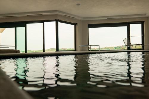 a swimming pool in a building with windows at La Villetta Nicolini in Barbaresco