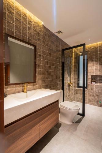 a bathroom with a tub and a toilet and a sink at Ladyfit House in Thôn Trường Giang