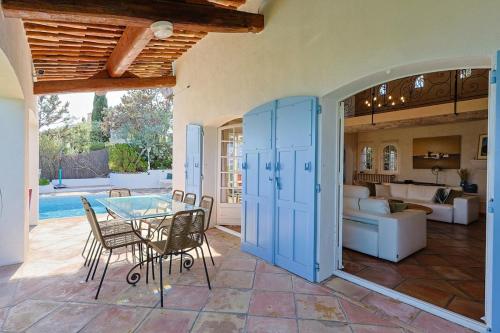 a living room with a glass table and chairs at Villa avec vue panoramique et piscine à Saint-Raphael in Saint-Raphaël