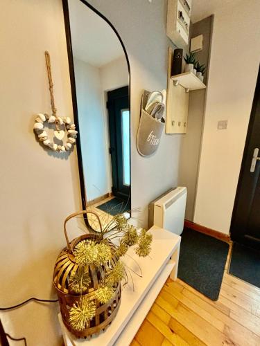 a bathroom with a mirror and a basket on a counter at Sea Whispers - My Charming Costal Retreat in Youghal in Youghal