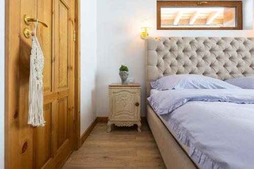 a bedroom with a bed with a tufted headboard at Villa Eliyas with Jacuzzi near the Pirin Golf Resort in Razlog