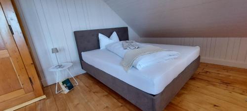 a bed with white sheets and pillows in a room at Refugio Heiligkreuz in Hasle