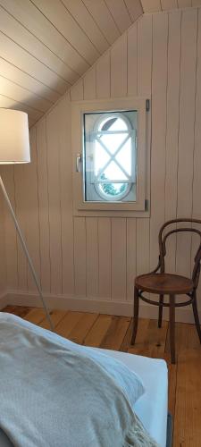 a room with a bed and a chair and a window at Refugio Heiligkreuz in Hasle