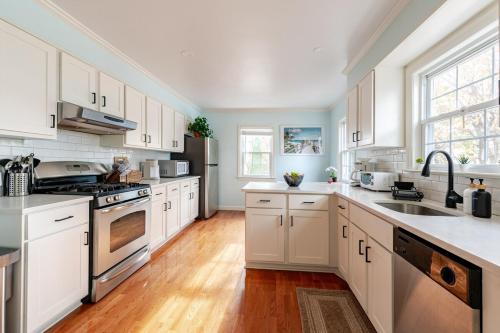 a large kitchen with white cabinets and a sink at Spacious 3 bedroom house 45mins to NYC great hotel alternative for big group in Port Chester