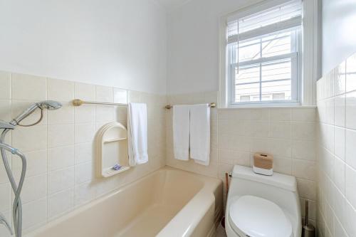 a bathroom with a tub and a toilet and a window at Spacious 3 bedroom house 45mins to NYC great hotel alternative for big group in Port Chester