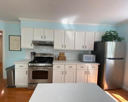 a kitchen with white cabinets and a stainless steel refrigerator at Spacious 3 bedroom house 45mins to NYC great hotel alternative for big group in Port Chester