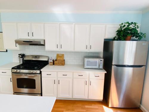 a kitchen with white cabinets and a stainless steel refrigerator at Spacious 3 bedroom house 45mins to NYC great hotel alternative for big group in Port Chester