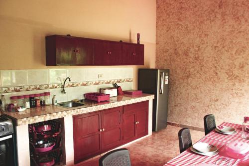 a kitchen with red cabinets and a stainless steel refrigerator at Quinta Los Pinos Cotoca in Cotoca