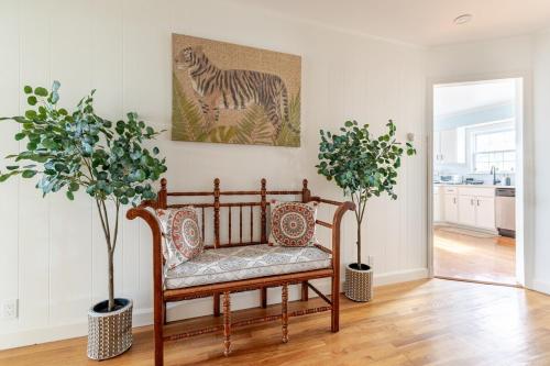 a living room with a bench and two potted trees at Spacious 3 bedroom house 45mins to NYC great hotel alternative for big group in Port Chester