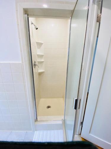 a shower with a glass door in a bathroom at Spacious 3 bedroom house 45mins to NYC great hotel alternative for big group in Port Chester