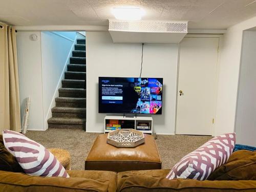 a living room with a couch and a flat screen tv at Spacious 3 bedroom house 45mins to NYC great hotel alternative for big group in Port Chester