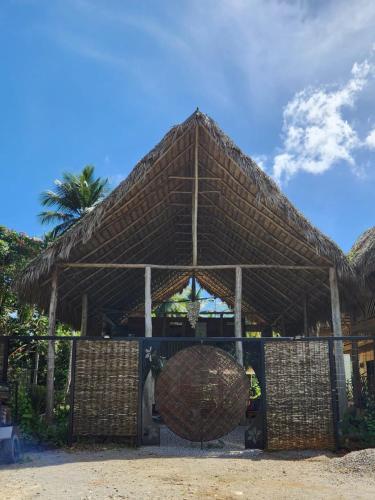 a large straw roofed building with a palm tree at Boho villas and spa in El Valle