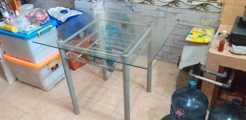 a glass table in a kitchen with a refrigerator at Teras damai Minangkabau in Duku