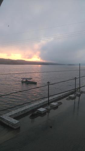 a boat in the water with the sunset in the background at Hotel Posada Tayazal in Flores