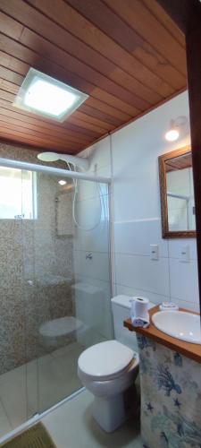 a bathroom with a toilet and a shower and a sink at Casa Dos Ventos Hospedagem Praia do Rosa in Praia do Rosa