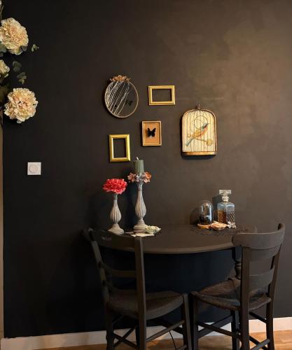 - une table à manger avec 2 chaises et des vases dans l'établissement Votre expérience insolite - Clair de lune, à Caen