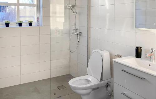 a white bathroom with a toilet and a shower at Nice Home In Västervik With Lake View in Västervik