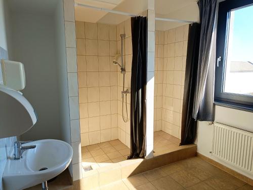 a bathroom with a shower and a sink at Famulus Kollégium in Győr