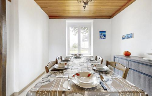 une salle à manger pourvue d'une table avec des assiettes et de l'argenterie dans l'établissement 3 Bedroom Beautiful Home In Pont-Aven, à Pont-Aven