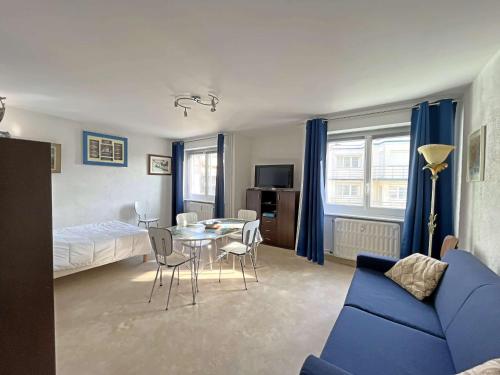 un salon avec un canapé bleu et une table dans l'établissement Studio les pieds dans l'eau à Berck-Plage avec parking privatif - FR-1-646-18, à Berck-sur-Mer